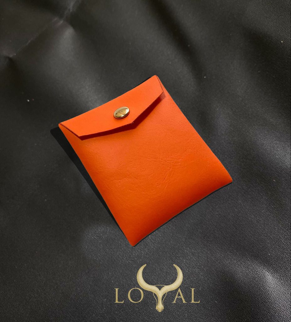 Túi đựng trang sức bằng da nhân tạo màu cam đất với nút bấm kim loại, phong cách tối giản hiện đại